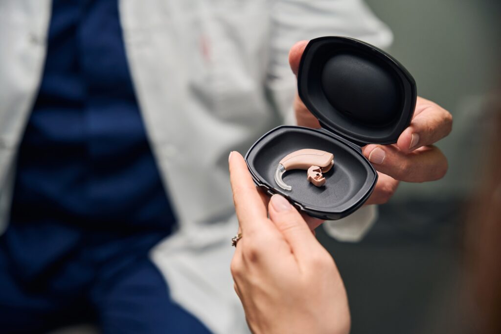 Doctor showing hearing aid in a black case