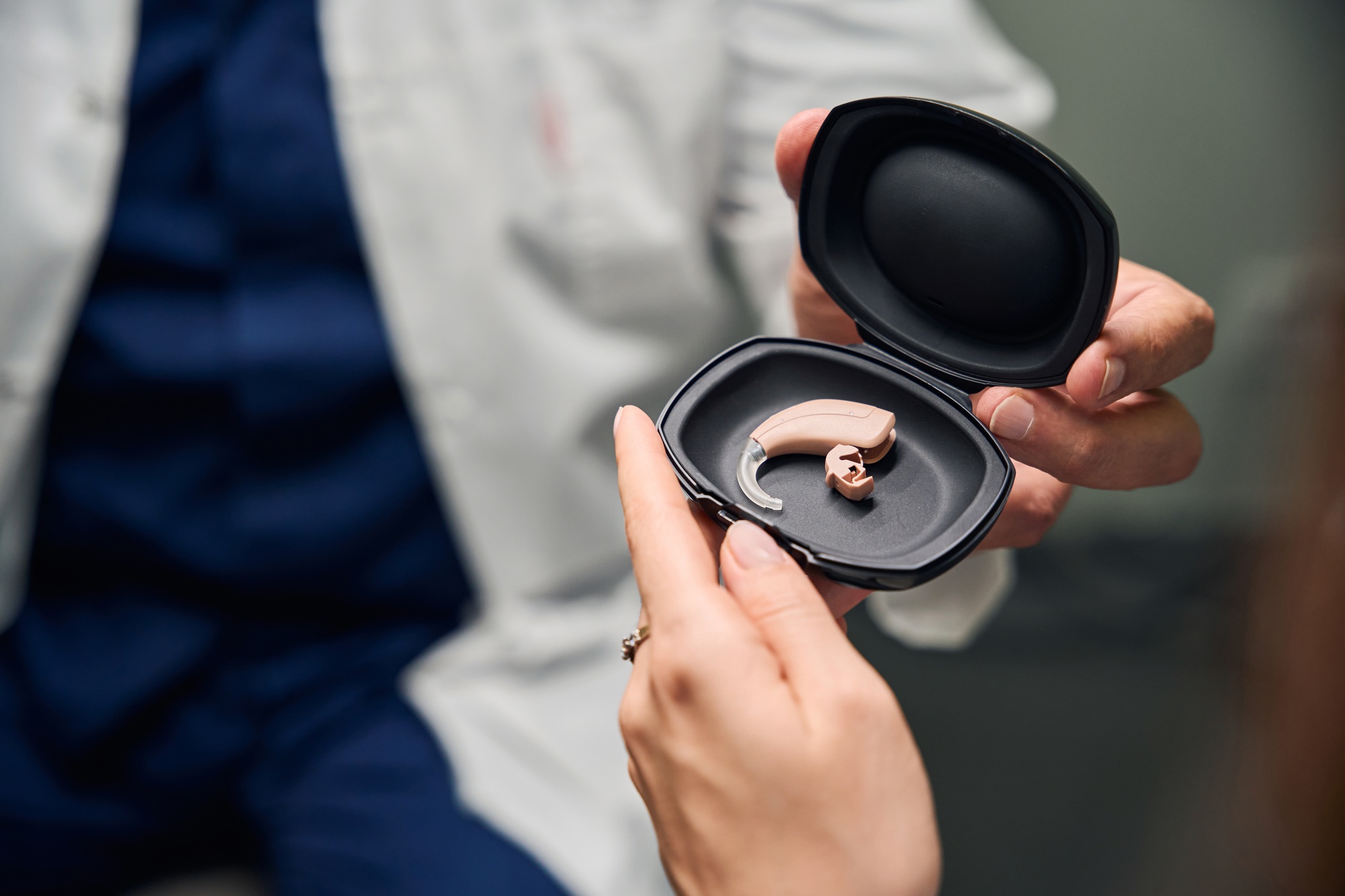 Doctor showing hearing aid in a black case